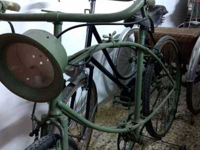 Una bicicletta verde oliva in dotazione ai bersaglieri durante la Prima guerra mondiale: ha due gomme piene, un faro anteriore dove accoglieva una candela ed � sorprendentemente pieghevole
